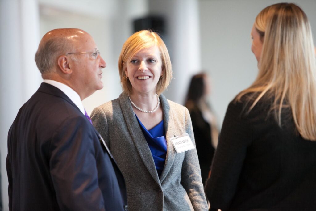 Photo of Hannah speaking with colleagues in business attire at an advocacy event